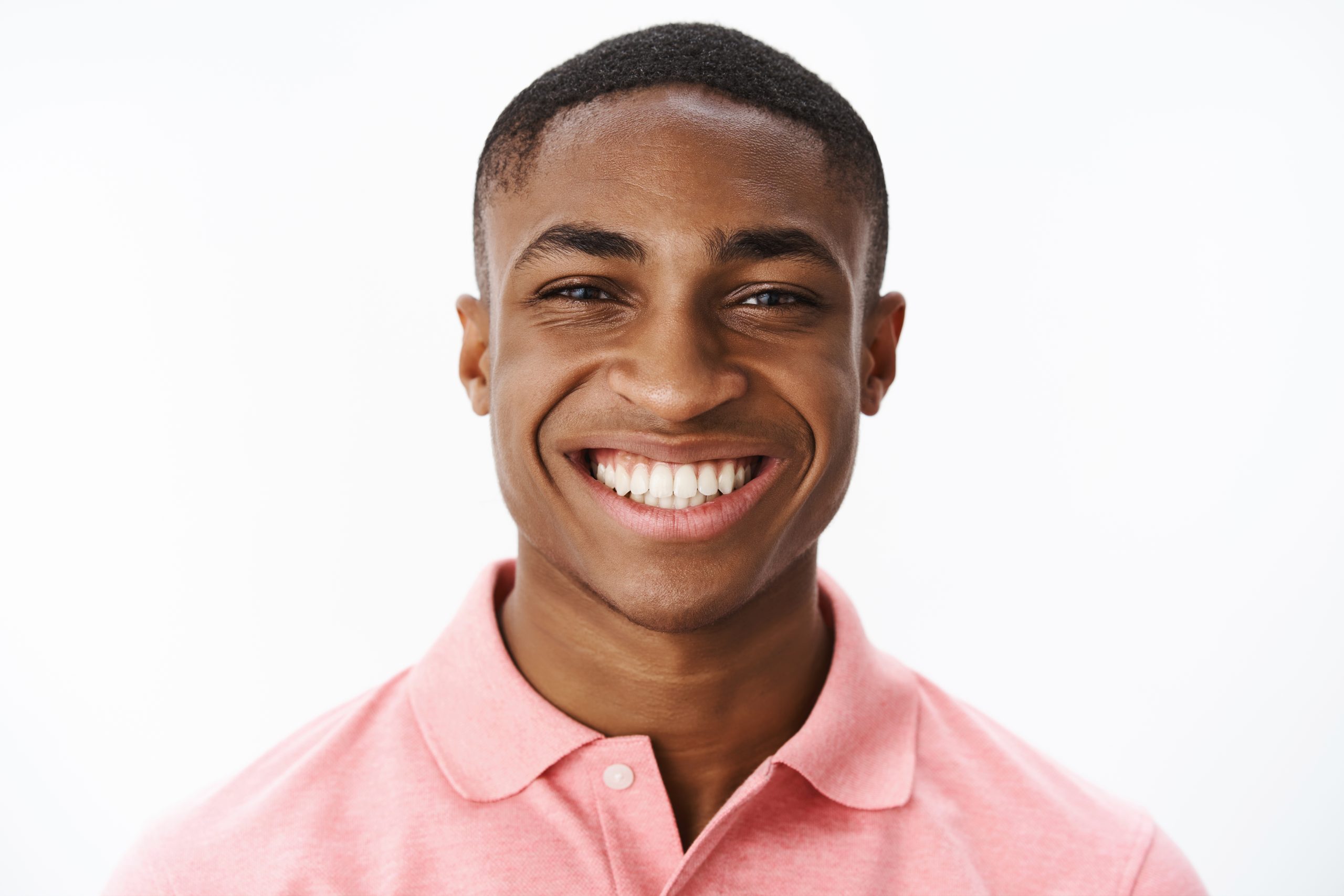headshot of happy successful and delighted young african american male student smiling broadly with joy and delight showing perfect white teeth, enjoying life, feeling uplifted and satisfied